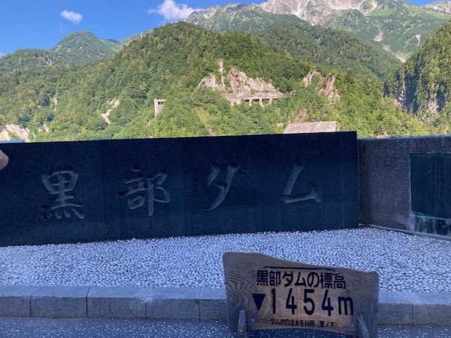 黒部ダムの石碑と背景の山々